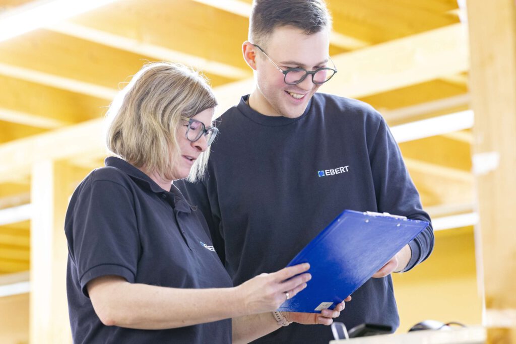 Zwei Mitarbeiter von Ebert Kunststoffbearbeitung besprechen Details zu technischen Plastikverarbeitungsplaenen auf der Schwaebischen Alb.