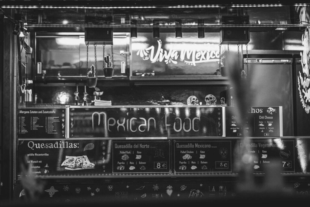 Ein Foodtruck mit vielfaeltigem internationalen Streetfood-Angebot, im Schwarz-Weiß-Stil aufgenommen.