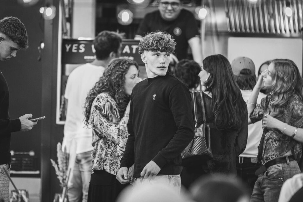 Gruppe von Menschenunterhaelt sich froehlich bei einem Foodtruck-Event.