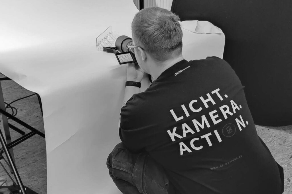 Mann richtet Fotostudio mit Hintergrundbeleuchtung ein