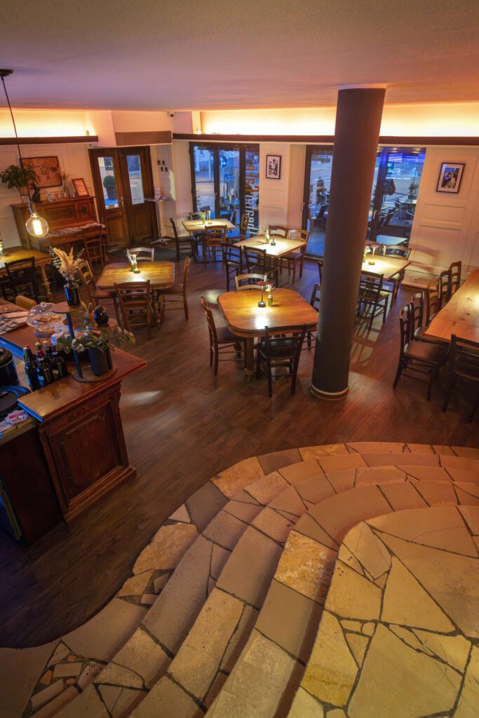 Gemuetliches Restaurantinterieur mit Holztischen und warmem Licht.