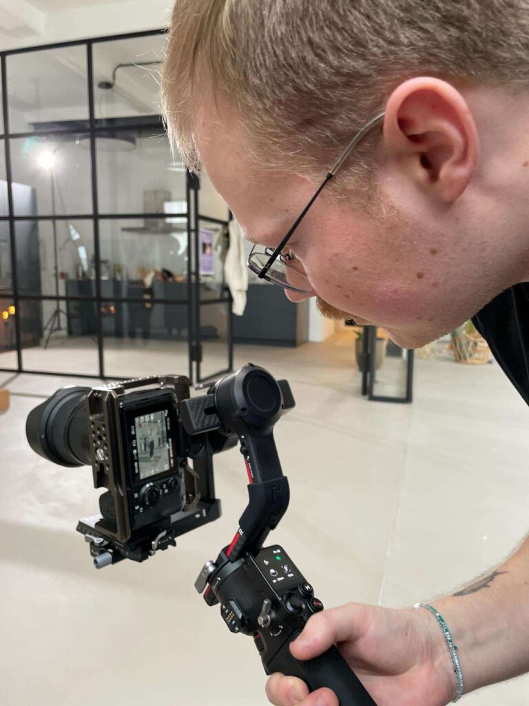 Person beim Einrichten einer Kamera fuer einen Videodreh im Innenbereich