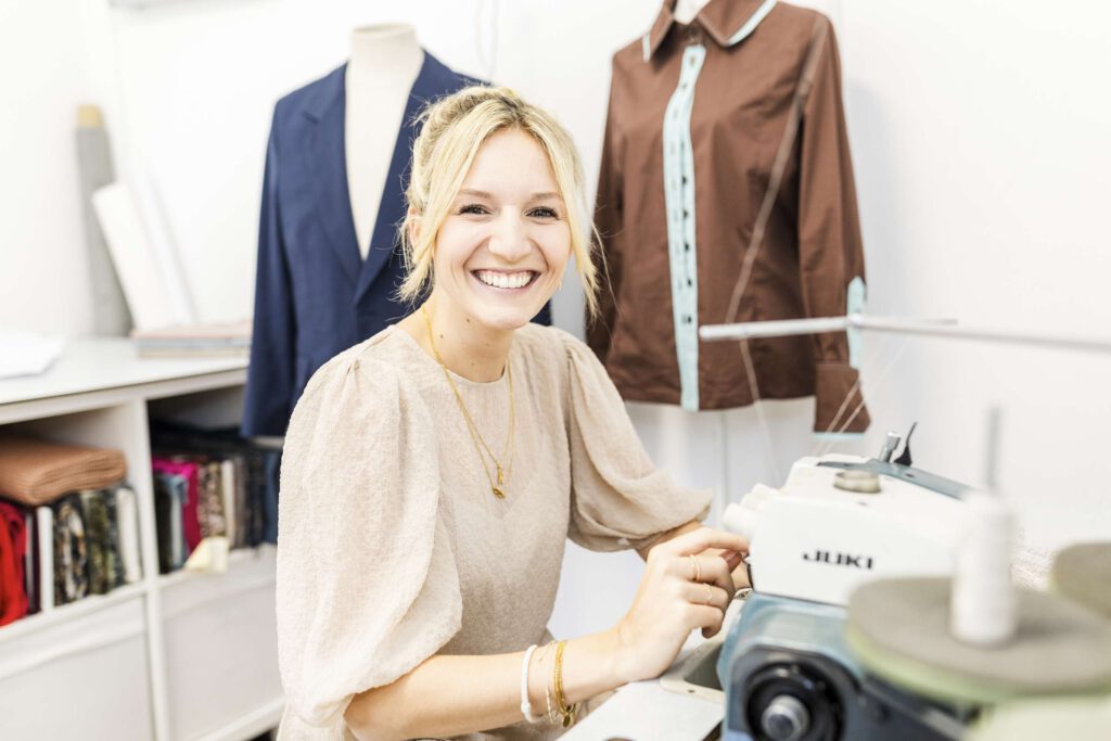 Eine Modedesignerin arbeitet an einer Schneiderpuppe in ihrem Atelier.