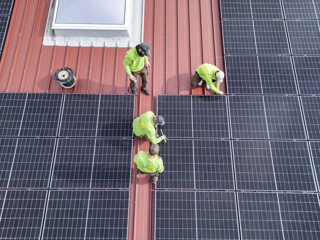 Mitarbeiter installieren Solarpaneele auf einem Dach bei Raichle in Duermentingen.