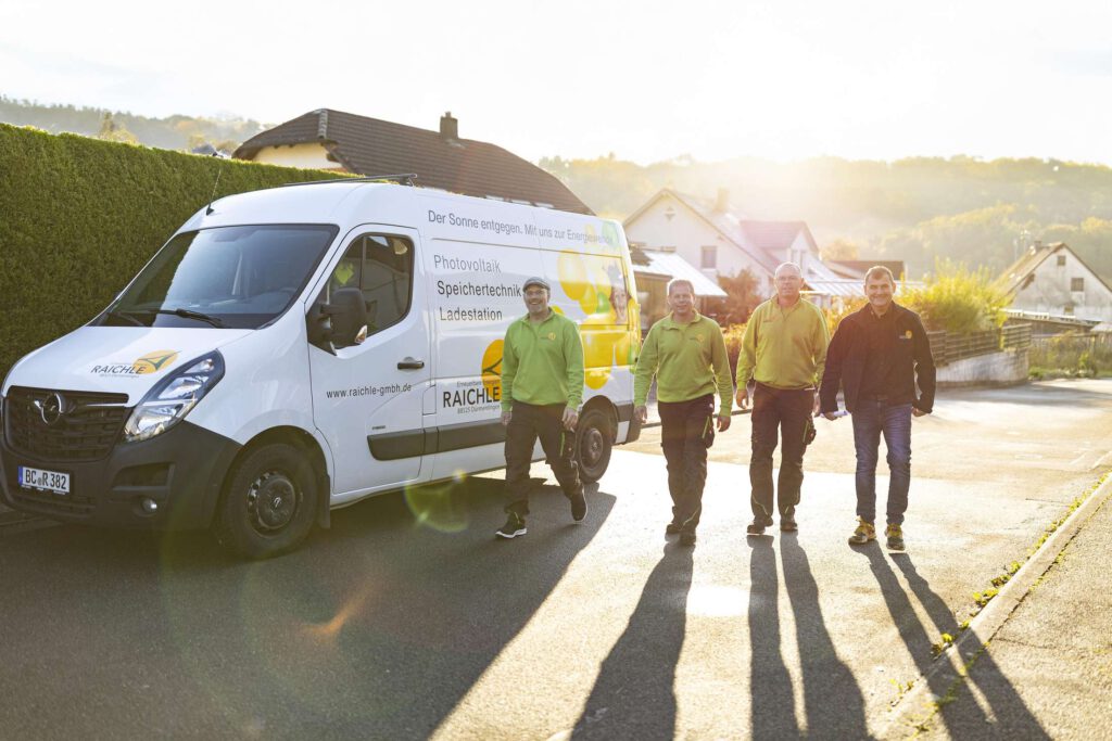 Das Team der Raichle GmbH vor einem Firmenfahrzeug bei der Arbeit an nachhaltigen Energieloesungen.