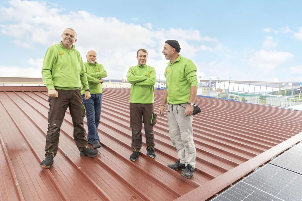 Ein Team von Raichle GmbH auf einem Dach, das ueber eine Photovoltaikanlage beraet.