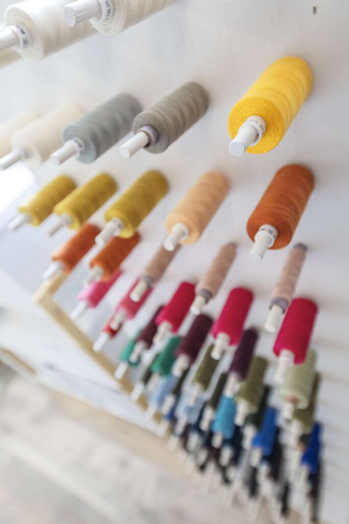 Verschiedene bunte Spruehflaschen und Farbproben in einer Reihe.