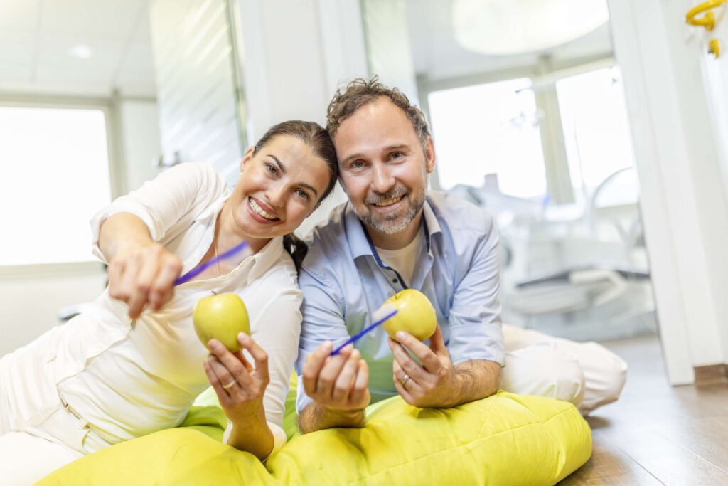 Zahnarztteam in der Praxis Stegherr & Stegherr in Albstadt zeigt Aepfel und laechelt freundlich.